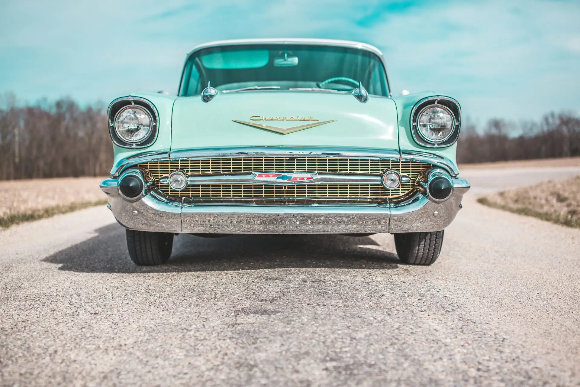 low-angle photo of classic teal Chevrolet car
